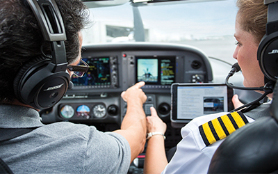 Two pilots discussing while flying a plane